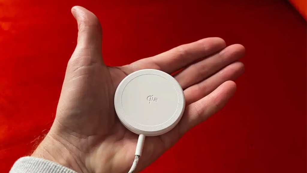 A hand holding a wireless charger